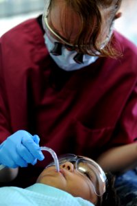 US Navy 110803-N-NY820-199 Hospital Corpsman 1st Class Kimberly Edwards cleans a patient's teeth at the Escuela Fray Casiano de Madrid medical site photo