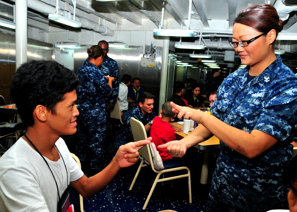US Navy 110802-N-BK435-031 Hospital Corpsman 2nd Class Victoria Lord uses sign language to communicate with a child from the International Children