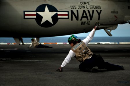 US Navy 110729-N-BT887-149 Aviation Structural Mechanic 3rd Class Tia Squires, from Missoula, Mont., signals the approval to launch an E-2C Hawkeye
