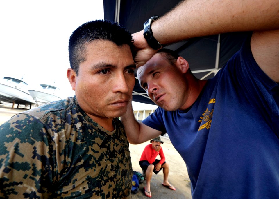 US Navy 110727-N-KB666-387 Chief Hospital Corpsman Nathanael Warren, right, inspects the ears of Arnulfo Lopez after problems descending during div