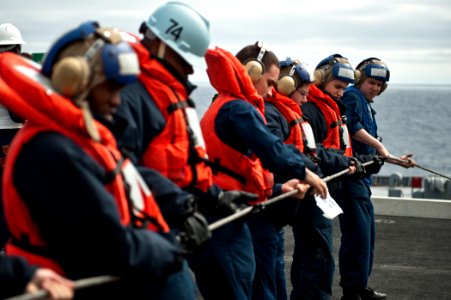 US Navy 110730-N-BT887-134 Sailors provide line tension during a replenishment at sea aboard USS John C. Stennis (CVN 74)