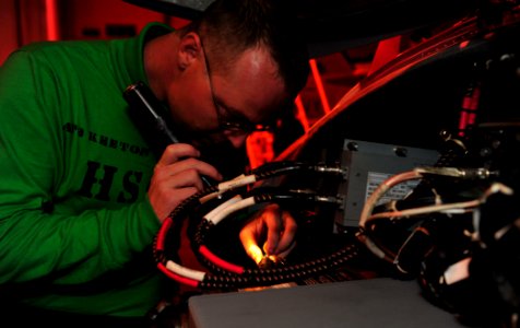 US Navy 110730-N-GC412-046 Aviation Electronics Technician 2nd Class John Keeton re-pins a DTIU connector on an MH-60S Sea Hawk helicopter aboard U