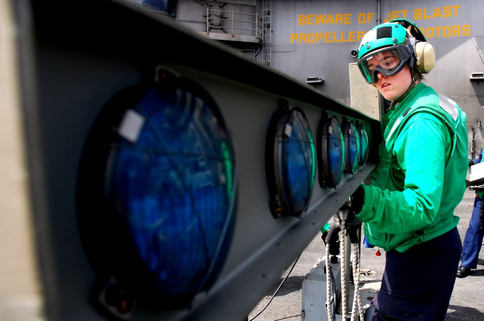 US Navy 110801-N-GL340-124 Interior Communications Electrician 3rd Class Bethany Palenik, from St. Louis, disassembles an improved fresnal lens opt