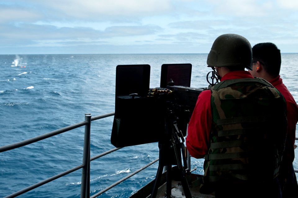 US Navy 110731-N-BT887-099 Aviation Ordnanceman Airman Hector Espinosa fires a .50-caliber machine gun at a target during a training exercise aboar