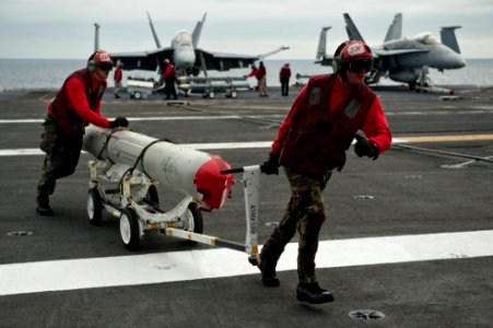 US Navy 110729-N-BT887-126 Aviation Ordnanceman 3rd Class Joel Pflum and Aviation Ordnanceman 1st Class Joshua Donahue transfer ordnance across the
