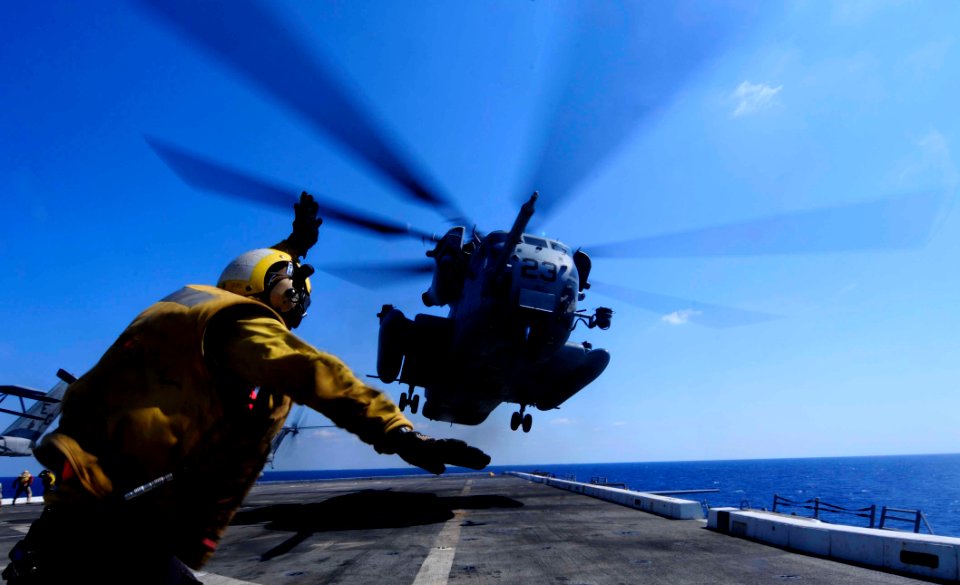 US Navy 110802-N-OS574-201 Aviation Boatswain's Mate (Handling) 3rd Class Eddy Parra gives the signal to launch a CH-53 Sea Stallion helicopter