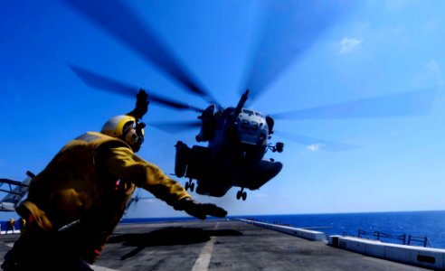US Navy 110802-N-OS574-201 Aviation Boatswain's Mate (Handling) 3rd Class Eddy Parra gives the signal to launch a CH-53 Sea Stallion helicopter