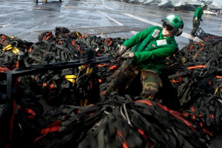 US Navy 110822-N-BT887-011 Logistics Specialist Seaman Rachel Foster wraps cargo nets on the flight deck
