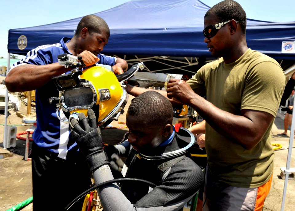 US Navy 110804-N-KB666-083 Ordinary Seaman Phillip Rowe, left, and Petty Officer Darin Atkinson, right, prepare Ordinary Seaman Howard Clark for jo