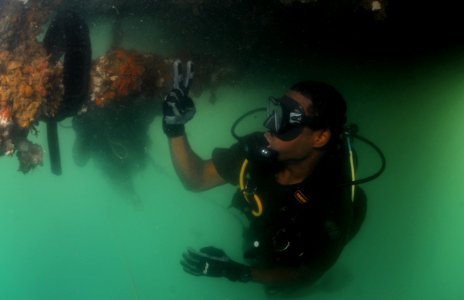 US Navy 110729-N-XD935-203 Royal Bahamas Defense Force diver Able Body Seaman Raynaldo Farquharson signals that he has found an inert training mine