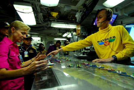 US Navy 110805-N-AW206-064 Handler Lt. Cmdr. Eric Harrington explains flight deck operations to U.S. Ambassador to Thailand Kristie A. Kenney
