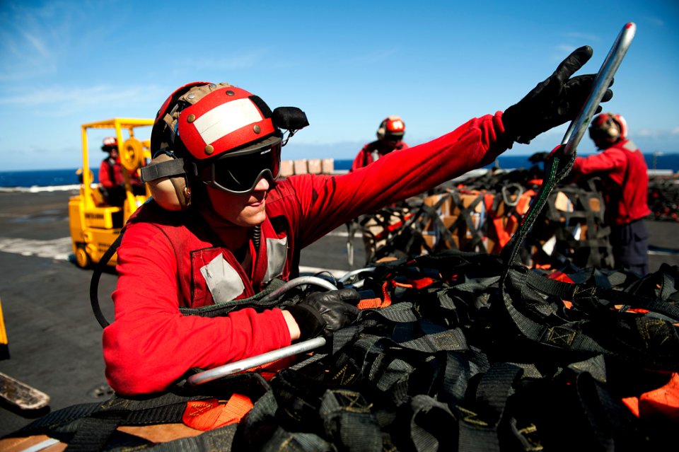 US Navy 110807-N-BT887-478 Aviation Ordnanceman 3rd Class Robert Chirdon unwraps cargo during a vertical replenishment aboard USS John C. Stennis (