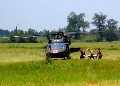 US Navy 110802-N-SD610-001 Seabees assigned to Naval Mobile Construction Battalion (NMCB) 7 transport a fellow Seabee to an awaiting Army National