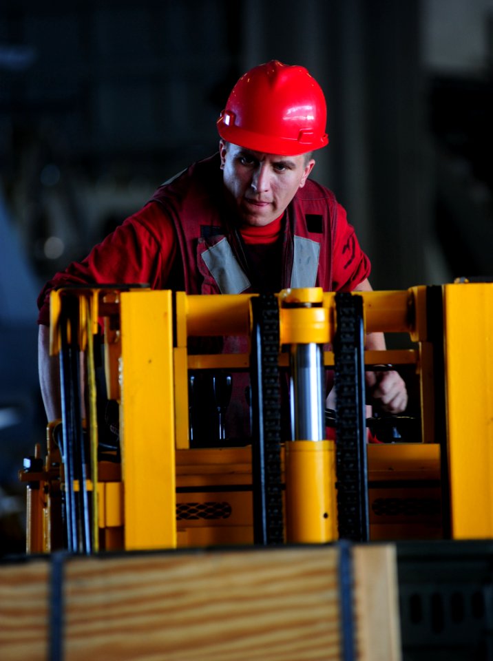 US Navy 110807-N-OI955-102 Aviation Ordnanceman 3rd Class Robert West, from San Diego, operates a forklift in the hangar bay aboard the Nimitz-cla
