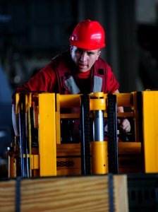 US Navy 110807-N-OI955-102 Aviation Ordnanceman 3rd Class Robert West, from San Diego, operates a forklift in the hangar bay aboard the Nimitz-cla