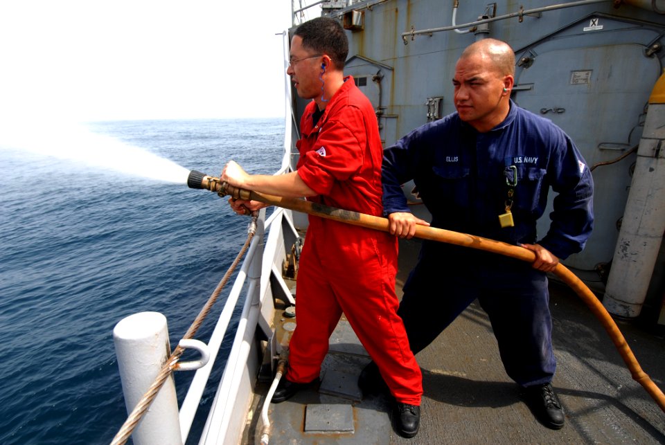 US Navy 110808-N-DU438-449 Damage Controlman 1st Class Peter Martinez, left, and Damage Controlman Fireman Stephen Ellis conduct hose handling trai