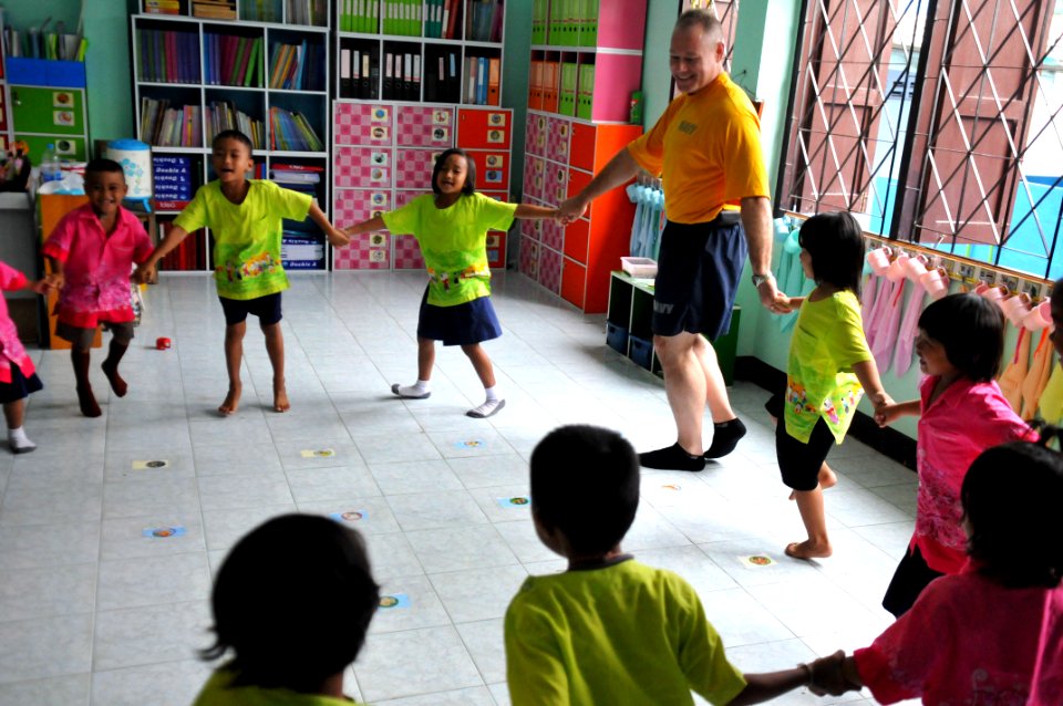 US Navy 110809-N-WW409-100 Command Master Chief Joseph Fahrney plays with students at the Wat Hua Yai School during a community service event in Pa