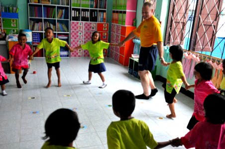 US Navy 110809-N-WW409-100 Command Master Chief Joseph Fahrney plays with students at the Wat Hua Yai School during a community service event in Pa photo