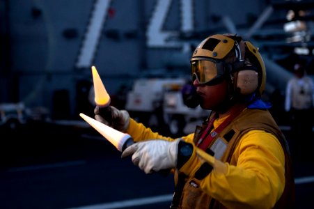 US Navy 110809-N-BT887-276 Aviation Boatswain's Mate 3rd Class Terrance Wever directs an E-2C Hawkeye aboard USS John C. Stennis (CVN 74)