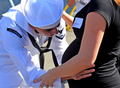 US Navy 110804-N-KS651-282 Culinary Specialist 3rd Class Abel Duran greets his wife and his unborn child after completing a five-month deployment a