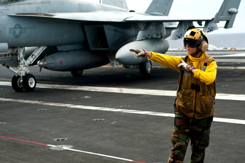 US Navy 110809-N-BT887-075 Aviation Boatswain's Mate (Handling) Airman Taylor Maxwell directs an F-A-18E Super Hornet aboard USS John C. Stennis (C