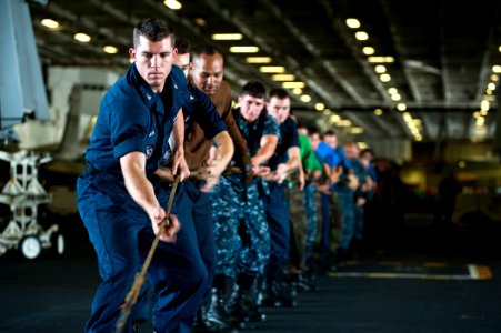 US Navy 110807-N-BT887-275 Mass Communication Specialist 3rd Class Joshua Keim heaves a line during a replenishment at sea aboard USS John C. Stenn photo