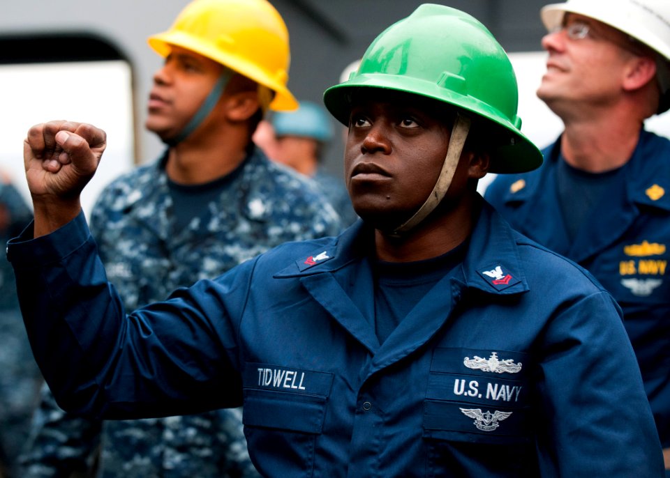 US Navy 110810-N-PB383-253 Boatswain's Mate 2nd Class Donte Tidwell signals to the crane operator while unloading the rigid-hull inflatable boat ab