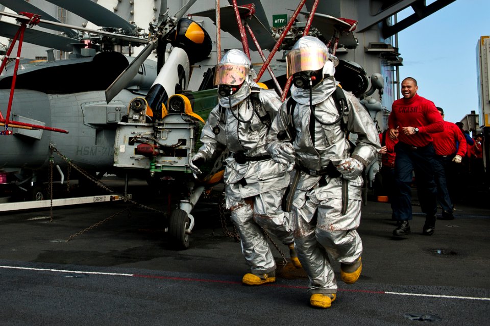 US Navy 110805-N-BT887-489 Aviation Boatswain's Mate Airman Patrick Sumbler, left, and Aviation Boatswain's Mate 3rd Class Jason Williams run acros