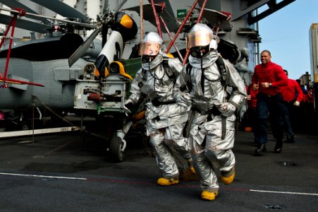 US Navy 110805-N-BT887-489 Aviation Boatswain's Mate Airman Patrick Sumbler, left, and Aviation Boatswain's Mate 3rd Class Jason Williams run acros