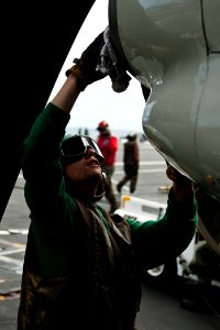 US Navy 110809-N-BT887-227 viation Machinist's Mate 3rd Class Matthew Varga wipes down an E-2C Hawkeye aboard USS John C. Stennis (CVN 74)