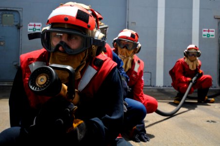 US Navy 110810-N-YM590-035 Navy Sailors man an aqueous film forming foam hose during a flight deck fire drill aboard the guided-missile cruiser USS