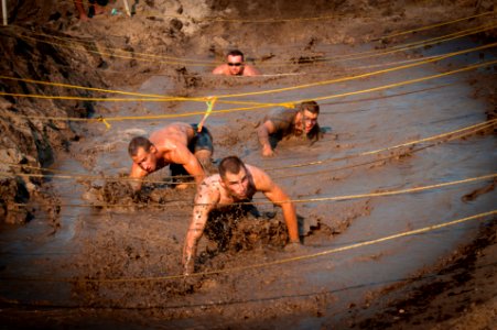 US Navy 110813-N-XS652-351 Runners navigate an obstacle during the 11th annual Armed Services YMCA Mud Run at Joint Expeditionary Base Little Creek