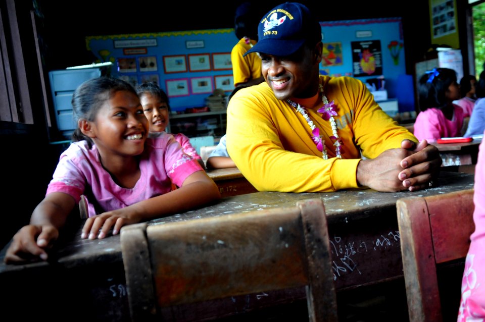 US Navy 110809-N-WW409-313 Yeoman 2nd Class Joel Carter plays with students at the Thung La Han School during a community service event in Pattaya