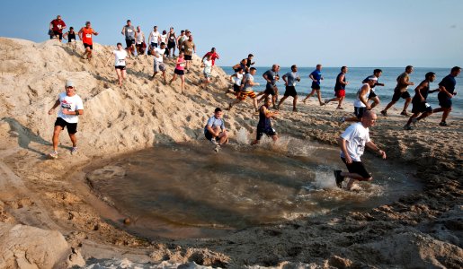 US Navy 110813-N-XS652-086 Runners navigate the first water pit during the 11th annual Armed Services YMCA Mud Run at Joint Expeditionary Base Litt