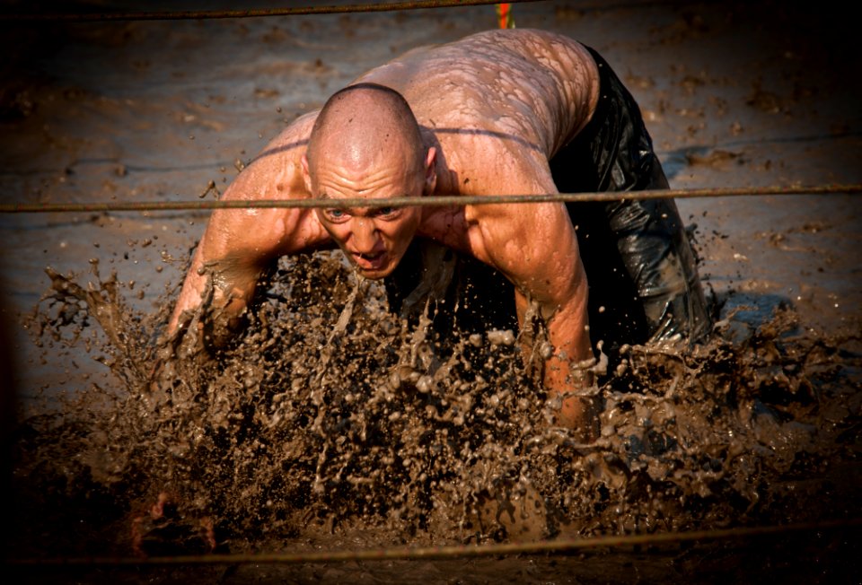 US Navy 110813-N-XS652-527 A runner navigates an obstacle during the 11th annual Armed Services YMCA Mud Run at Joint Expeditionary Base Little Cre