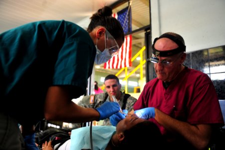 US Navy 110809-F-NJ219-082 Cmdr. Jonathon McIntosh fills a patient's cavity at the Barranca Municipal Gym medical site in Barranca, Costa Rica photo