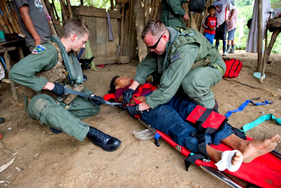 US Navy 110810-N-RM525-537 Chief Naval Air Crewman Justin Crowe, right, and Naval Air Crewman 3rd Class Joe Wainscott strap an injured boy photo