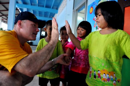 US Navy 110809-N-WW409-030 Command Master Chief Joseph Fahrney plays with students at the Wat Hua Yai School during a community service event in Pa photo
