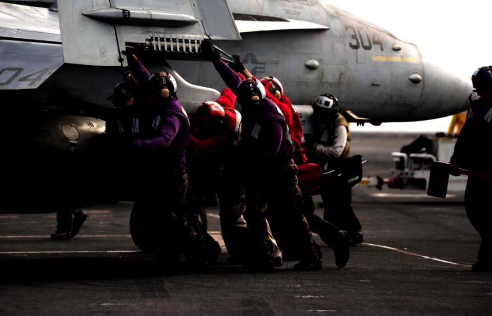 US Navy 110812-N-ZZ999-448 ailors push an F-A-18C Hornet during flight USS John C. Stennis (CVN 74)operations aboard the