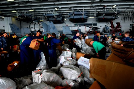 US Navy 110811-N-XE109-735 Sailors sort mail in the hangar bay aboard the aircraft carrier USS George H.W. Bush (CVN 77)