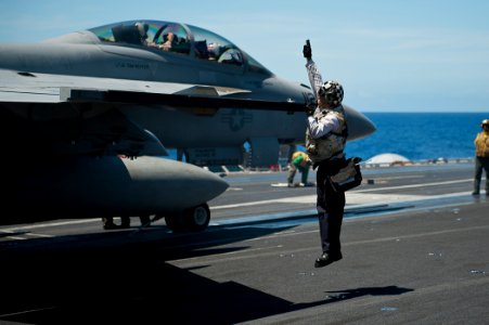 US Navy 110810-N-BT887-152 Aviation Structural Mechanic 3rd Class Sean Vasquez performs a pre-flight check on the wing of an F-A-18F Super Hornet a