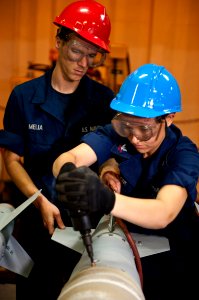 US Navy 110812-N-DX615-179 Aviation Ordnanceman 2nd Class Nadezda Coe tightens the tail assembly of a GBU-38 joint direct attack munitions 500-poun