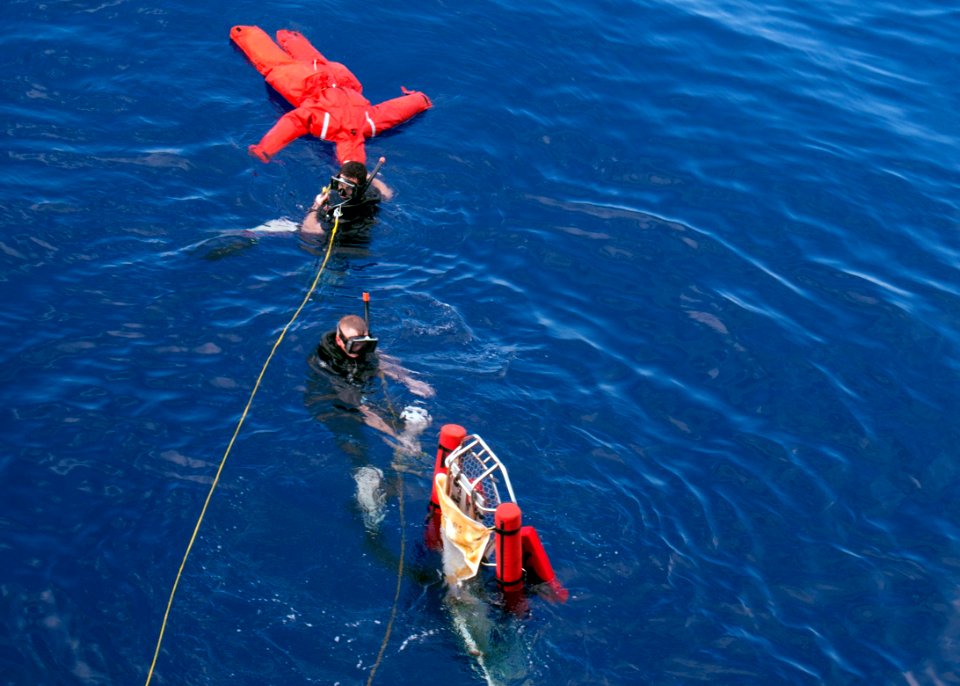 US Navy 110812-N-EA192-098 Search and rescue swimmers prepare to put Oscar' the man overboard training dummy into a stretcher