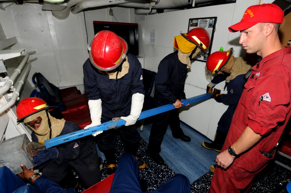 US Navy 110812-N-DU438-132 Machinery Repairman 1st Class Brandon Woodard, right, supervises as Sailors place a metal shoring against a bulkhead dur