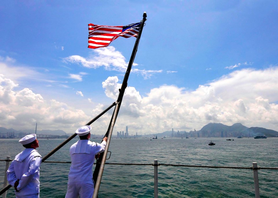 US Navy 110812-N-EE987-461 Machinist's Mate Fireman Joseph Costello, from Marinette, Wis., raises the American flag on the flight deck of the aircr