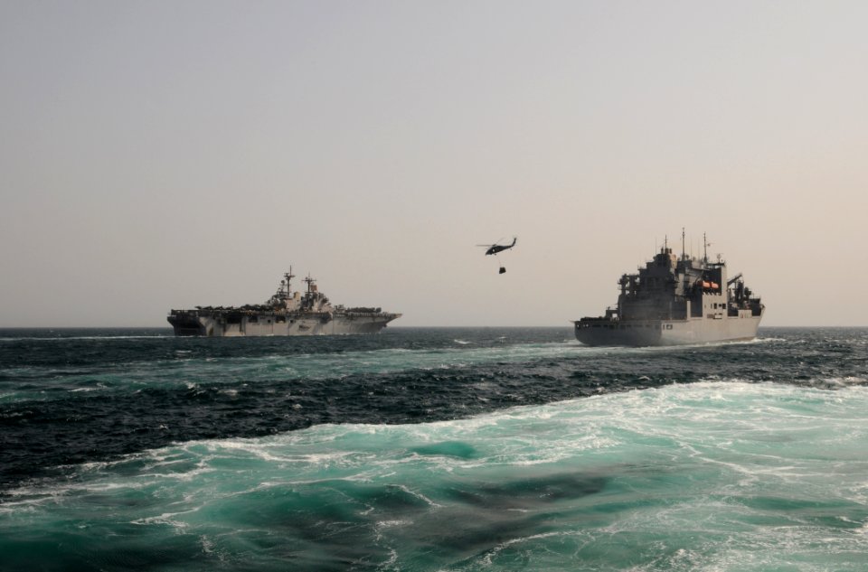 US Navy 110812-N-XQ375-836 An SH-60 Sea Hawk helicopter transfers pallets of stores from the USNS Wally Schirra (T-AKE 8) to the USS Boxer (LHD 4)