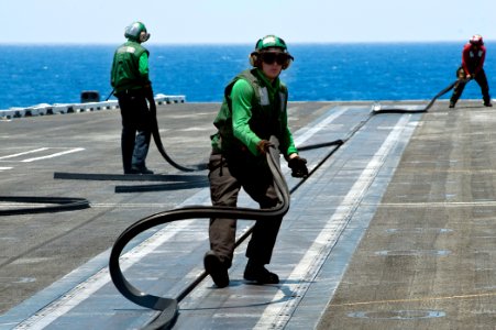 US Navy 110811-N-BT887-025 Airman Arrick Chance removes a slot seal from catapult two aboard the Nimitz-class aircraft carrier USS John C. Stennis
