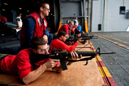 US Navy 110812-N-BT887-193 Aviation Ordnanceman Airman Zac Hommes fires an M-16A2 assault rifle during a weapons qualification aboard the Nimitz-cl