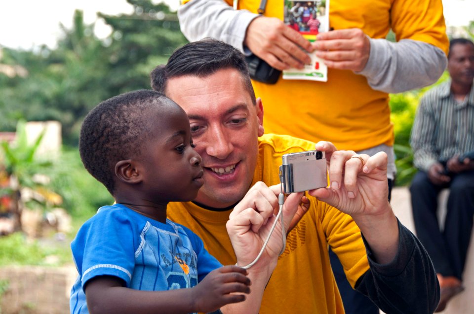 US Navy 110818-N-XK513-070 A Sailor shares photos with a Ghanaian child