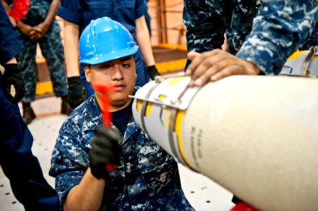 US Navy 110812-N-DX615-005 Aviation Ordnanceman 2nd Class Jorge Carino loads a GBU-38 joint direct attack munitions (JDAM) 500-pound bomb aboard th